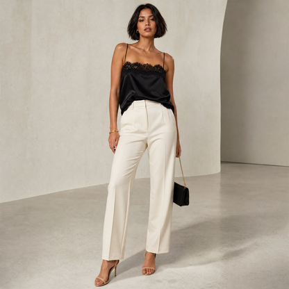 Saga Lace Cami in Black — hero shot styled with cream trousers